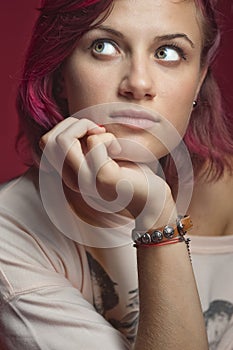 The red-haired girl rests her head on the palm of her hand.