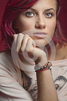 The red-haired girl rests her head on the palm of her hand.