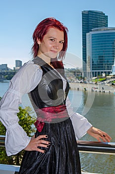 Red-haired girl stands on the bridge. Moscow. Moscow City Business Center