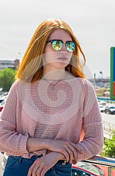 Red-haired girl is in sunglasses