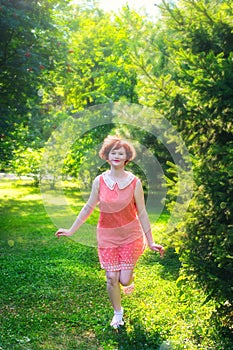 Red haired girl on a sunny day having fun in a park