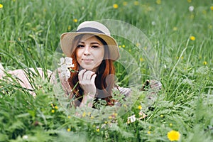 Red-haired girl walks in a spring blooming apple orchard