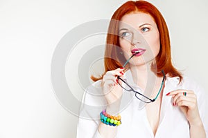 Red-haired girl in a white blouse and black glasses. Colorful an