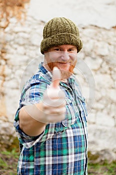 Red haired man with blue plaid shirt saying Ok