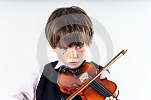 Red-haired preschooler boy with violin