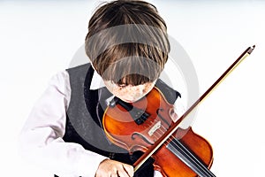 Red-haired preschooler boy with violin