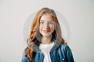 Red-haired pretty teenager girl smiling at the camera. Isolate on white background. Blue-eyed child with a benevolent