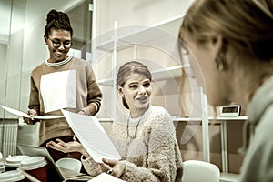 Red-haired student wearing necklace talking to groupmate