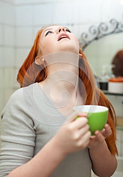 Red-haired teen girl gargling throat