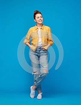 Red haired teenage girl in shirt and torn jeans