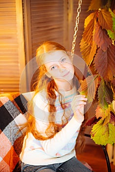 Red-haired teenager girl in a studio in the fall scenery