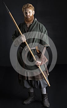 Red-haired Viking posing with weapons