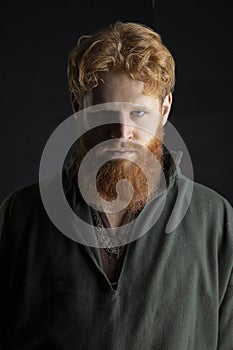 Red-haired Viking posing with weapons