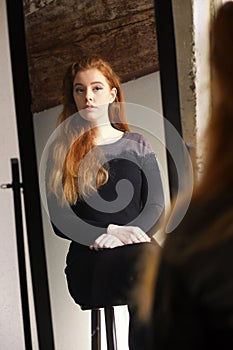 Red Haired Woman in Black Dress Looking at Herself in a Mirror