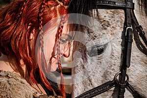 Red-haired woman with a faithful horse preparing for battle