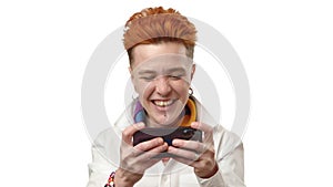 Red-haired woman focused and entertained while playing a game on phone