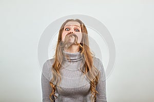 Red haired woman in gray sweater made her hair an imitation of man`s moustache