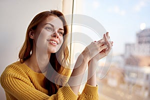 red-haired woman lies near the window dreamy look
