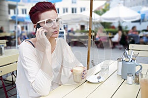 Red-haired woman outside talking on the phone