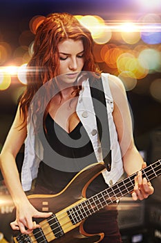 Red haired woman playing guitar on stage