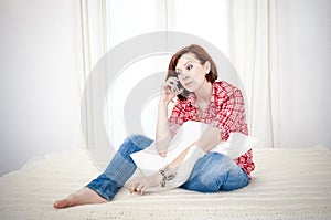 Red haired woman sad, worried talking on her cell mobile phone