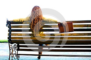 Red - haired woman sitting on bench with book