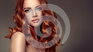 Red haired woman with voluminous, shiny and curly hairstyle.Flying hair.