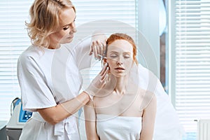 Beautiful woman gets beauty facial injections. Aesthetic Cosmetology.