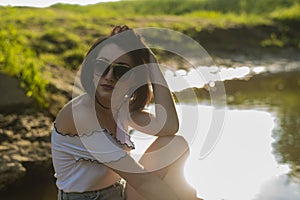 Red haired young girl wrapped in orange blanket posing near the swamp or lake with duckweed