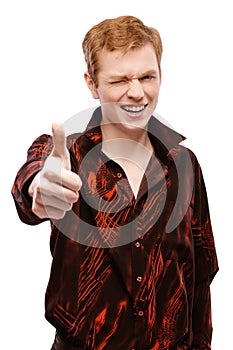 red-haired young man close-up in a red shirt raises his thumb up and smiling