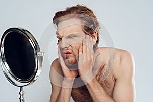 Red haired young man stroking beard