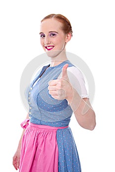 Red-haired young woman in Dirndl with thumbs up