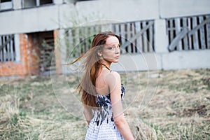 Red-haired young woman in floral dress