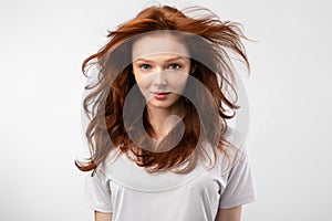 Red-Haired Young Woman With Loose Hair Posing Over White Background