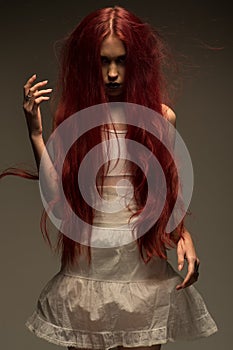 Red haired zombie woman in white cotton dress