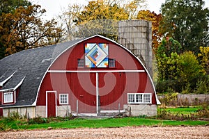 A red half circle quilt barn