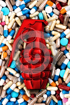 Red hand grenade on medicine capsules.