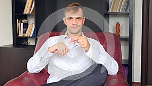 Red hand spinner, or fidgeting spinner, rotating on man`s hand. Man in a suit spinning a fidget spinner in his office at