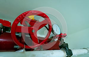 Red hand wheel of main supply water piping in the fire extinguishing system and white water supply pipe. Fire sprinkler system