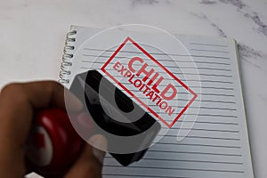 Red Handle Rubber Stamper and Child Exploitation text  on White Background photo