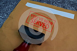 Red Handle Rubber Stamper and You`ve Been Served text isolated on the table