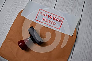 Red Handle Rubber Stamper and You`ve Been Served text isolated on the table
