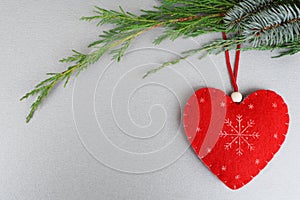 Red handmade heart on xmas tree branch