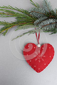 Red handmade heart on xmas tree branch