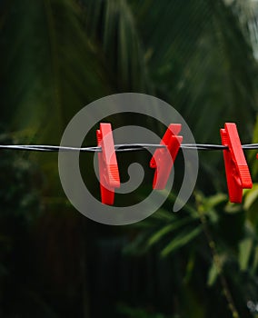 Red hanging clothes pin on a cable