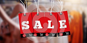 Red hanging sales tags on blur clothing store. Red sale price tag style banner design template