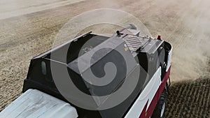 Red harvester machine cut wheat crop in rural field. Agriculture food production. Combine harvesting, collects ripe