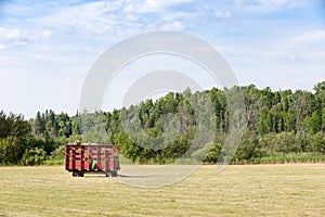 Red Hay Wagon in a Farm Field