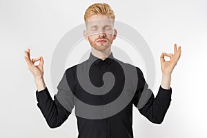 Red head man meditating in zen pose isolated over white background, namaste gesture jogi-man with closed eyes