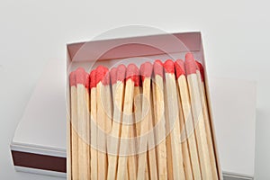 Red head matches in a white opened box on white background